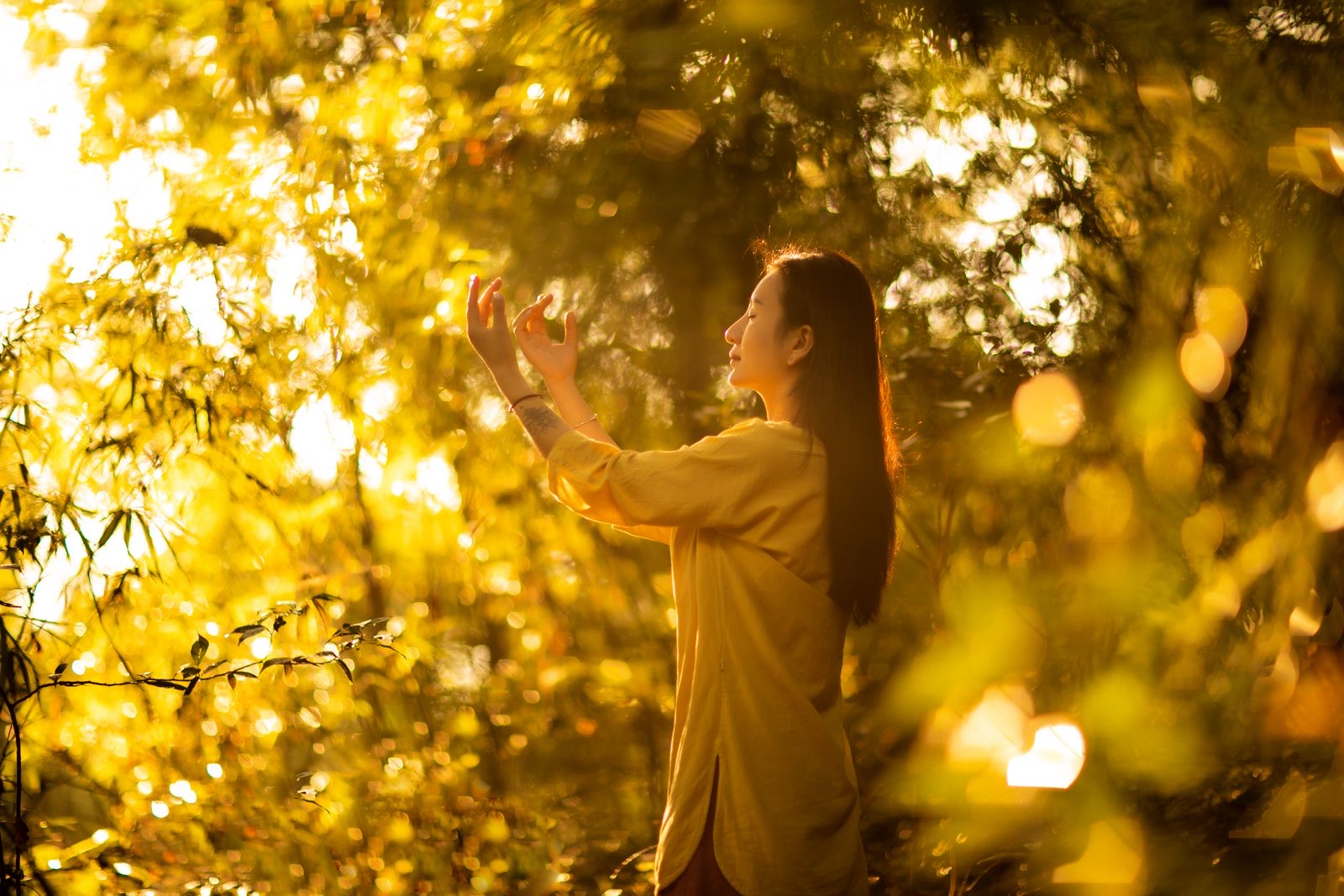 A woman meditating in golden light