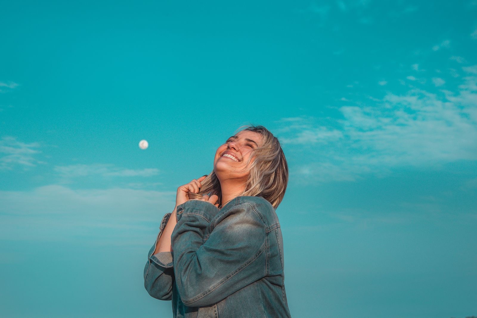 A refreshed, energized woman under a bright sky